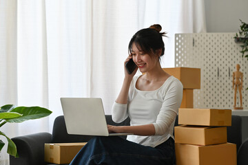 Portrait with Small business owner using a smartphone and working with laptop at home office, Online selling, SME, Drop shipping concept.