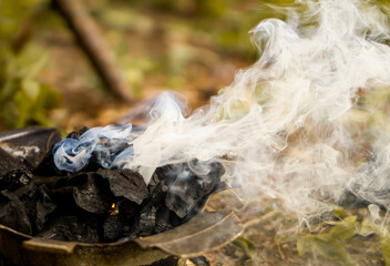 White smoke from wooden charcoal on the retro stove, cooking in the countryside, or fire camping in the forest.