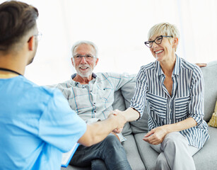 Obraz premium nurse doctor senior care caregiver help assistence retirement home hospital nursing man handshake