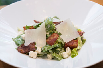 caesar salad with fresh vegatable, crispy bacon and large slice of cheese