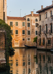 charming beautiful and calm canal with plants hanging over the wall in Venice, Italy 