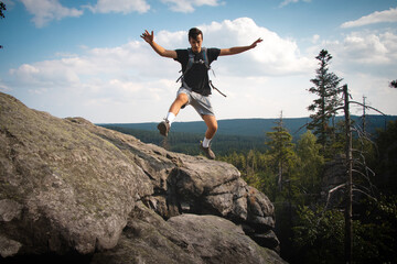 Swarthier type of man is running down a gravel hill, checking his every step to avoid injury. Active athlete runs over challenging terrain to improve fitness, coordination and precision of movement