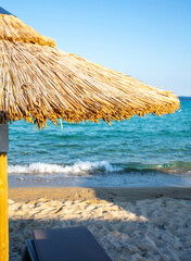 Fototapeta na wymiar Straw beach umbrella close up. Sunny day at sea. Summer holiday in Greece