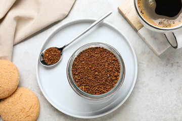 Glass jar of instant coffee, cup with drink and cookies on light table, flat lay