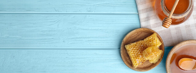 Flat lay composition with delicious honey on blue wooden table, space for text. Banner design