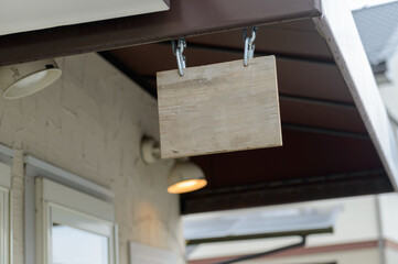 ショップの軒先に吊るされた木製看板　コピースペース - obrazy, fototapety, plakaty