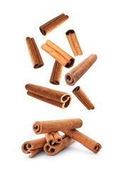 Aromatic cinnamon sticks falling on white background