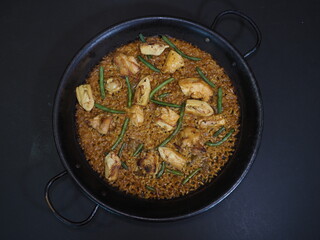Traditional Paella served in a dish isolated on dark background top view