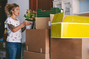 Woman preparing to move in a new house. Adult female enjoy unpacking her stuffs at home. Mortgage...