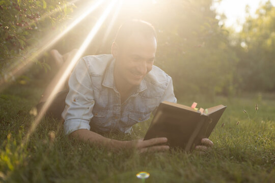 a man reads the Bible on the grass at a park