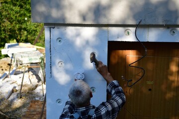 Mason works how to insulate the wall with nails and polystyrene