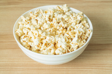 close up of popcorn in bowl on the wooden table.