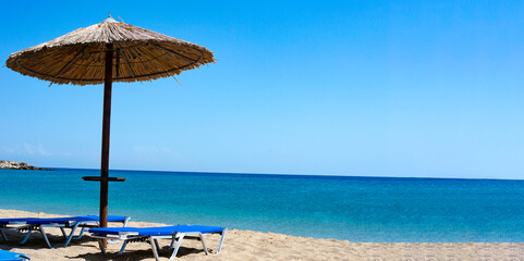 Empty sun beds on a beach in Greece. Two sun beds loungers White sand, sea view with horizon