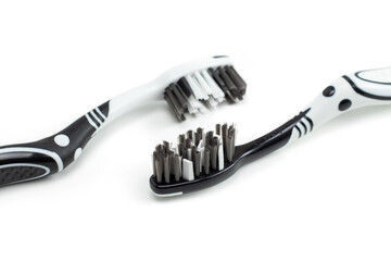 Obraz premium Two toothbrushes black and white color for dental care lies on the table on a white background