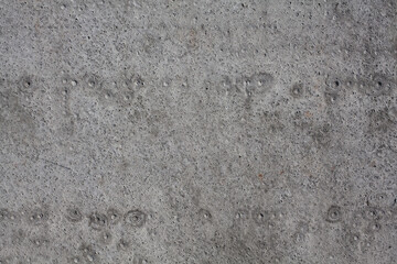 Dirty rough surface texture of sand screed cement, old gray concrete wall for background with uneven stains and tiny holes.