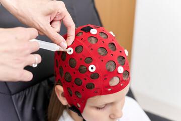 Doctor applying a liquid to a patient's headgear for biofeedback therapy