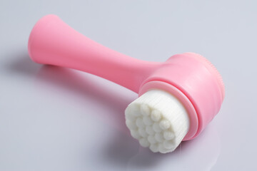 Fototapeta na wymiar Pink face cleansing brush, closeup. Cosmetic accessory