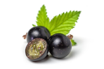 Group of black currants with leaves, one sliced in half