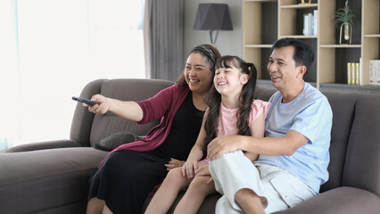 Fototapeta premium Happy family watching TV in living room