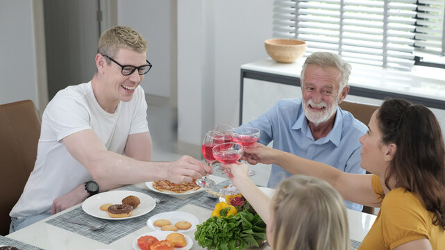 Happy multiracial family having dinner party In Kitchen Together - Group of friends dining at garden restaurant - Young people enjoying lunch break together - Food and beverage lifestyle concept.