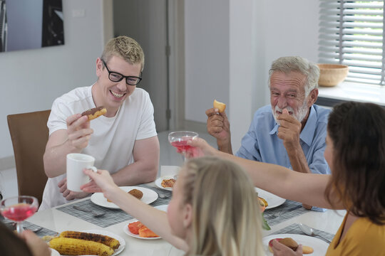 Happy multiracial family having dinner party In Kitchen Together - Group of friends dining at garden restaurant - Young people enjoying lunch break together - Food and beverage lifestyle concept.