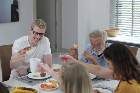 Happy multiracial family having dinner party In Kitchen Together - Group of friends dining at garden restaurant - Young people enjoying lunch break together - Food and beverage lifestyle concept.