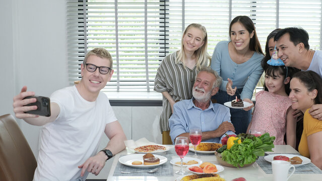 Happy multiracial family having dinner party In Kitchen Together - Group of friends dining at garden restaurant - Young people enjoying lunch break together - Food and beverage lifestyle concept.