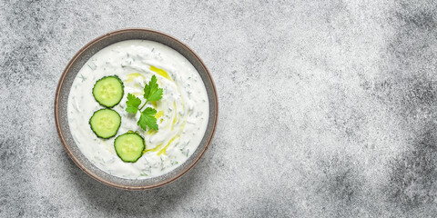 Tzatziki sauce. Gray grunge background. Greek sauce made from yogurt and vegetables. Top view, flat lay, copy space, banner