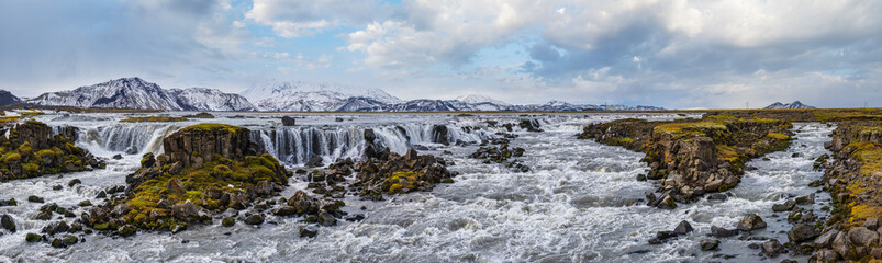 Season changing in southern Highlands of Iceland. Picturesque waterfal Tungnaarfellsfoss panoramic...