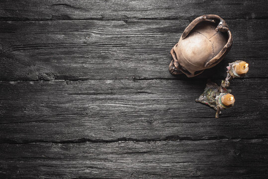 Skull and burning candle on the wooden table flat lay background with copy space.
