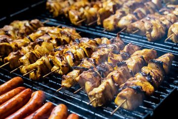 pattern meat skewers fried with a crust on a wooden skewer and sausage lies on the grill