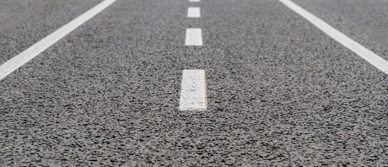 white lines on the asphalt close-up, road markings direction of movement