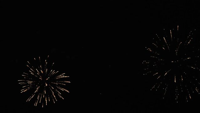 Gold and silver bright sparks of fireworks on the night black sky. Overall plan