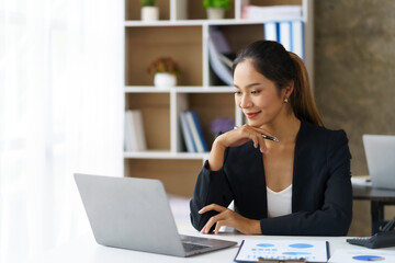 Asian businesswoman sitting happily working in the office