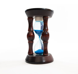 wooden hourglass with blue sand close up on isolated background