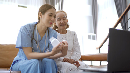 Fototapeta premium Asian doctor giving an advice and explaining to elder female patient.