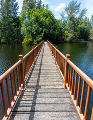 Wooden bridge over the lake of Wat Mai Khao temple, Phuket, THailand.