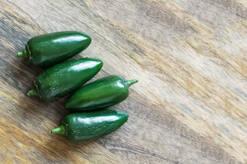 jalapeno fresh green hot peppers on wooden background with copy space
