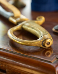 part of the sword handle gilded close-up on a wooden table