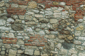 stone pattern of gray cobblestones bricks wall of an old house
