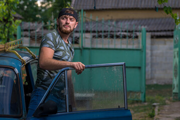 Handsome Young caucasian men, man  stubble beard, Portrait  wearing khaki shirt  countryside, gray background, nature, sexy men bodybuilder, summer day, blue old car vintage, reflection in glass, rain