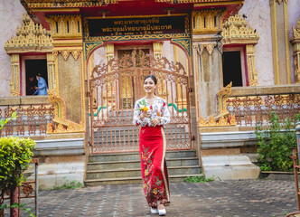 Fototapeta premium Beautiful Asian girl at big Buddhist temple dressed in traditional costume