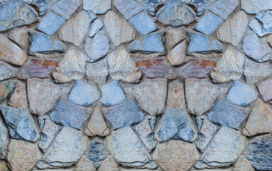 vertical pattern of gray cobblestones, uneven stones building