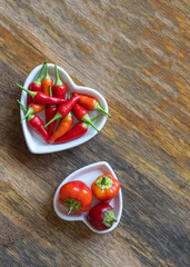 plate full of hot red peppers on wooden background with copy space