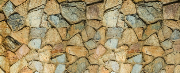 pattern of gray and brown cobblestones, uneven stones close-up