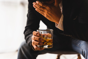 Alcoholism, depressed asian young man sleep on table while drinking alcoholic beverage, holding glass of whiskey alone at night. Treatment of alcohol addiction, suffer abuse problem alcoholism concept - obrazy, fototapety, plakaty