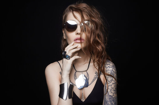 Beautiful sexy woman with tattoo. tattooed girl in sunglasses and jewelry. cheerful model