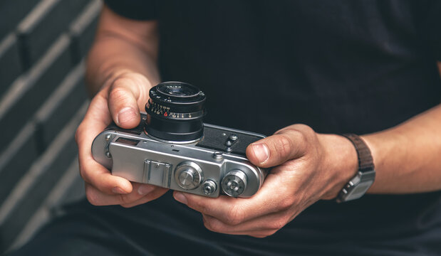 Close-up, vintage film retro camera in male hands.