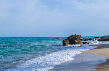 Turquoise shallow water surface and rocks stones on sea floor.