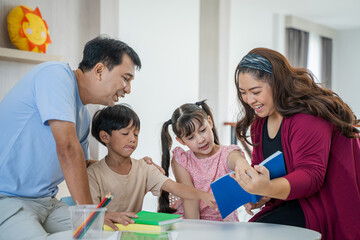 Asian father and mother teaching homework children,Happy family in living room at home,Activities of family members are good Education.